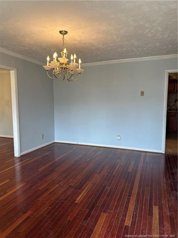 empty room with baseboards, a notable chandelier, dark wood finished floors, and a textured ceiling