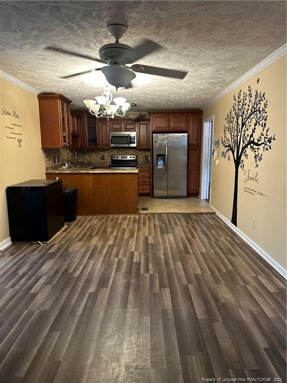 kitchen featuring a sink, dark wood-type flooring, appliances with stainless steel finishes, and crown molding