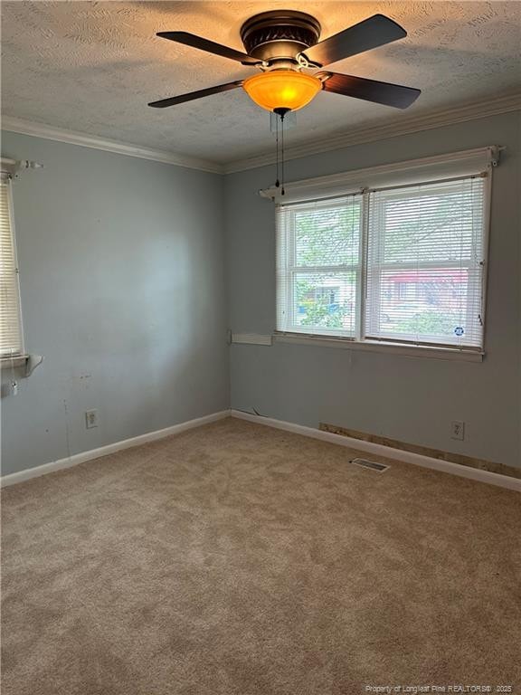 empty room featuring crown molding, carpet flooring, a ceiling fan, and a textured ceiling