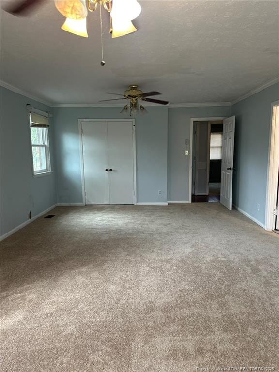 unfurnished room featuring baseboards, a textured ceiling, ceiling fan, and crown molding