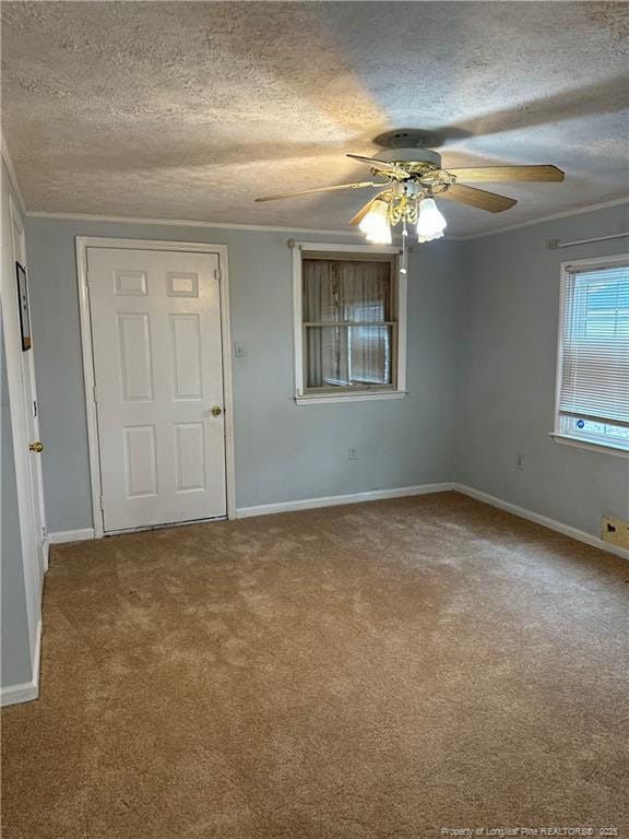 unfurnished room with crown molding, carpet flooring, a ceiling fan, and a textured ceiling