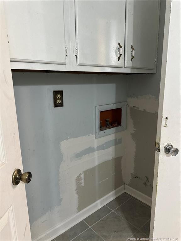 laundry area featuring baseboards, cabinet space, dark tile patterned flooring, and washer hookup