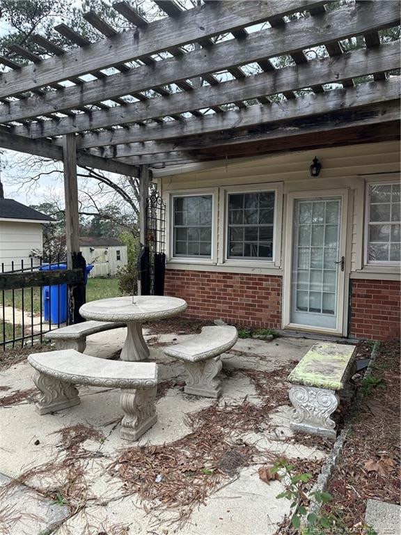 view of patio with a pergola and fence