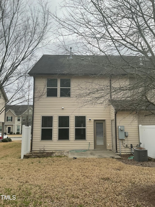 rear view of property featuring central air condition unit, a yard, and a patio area