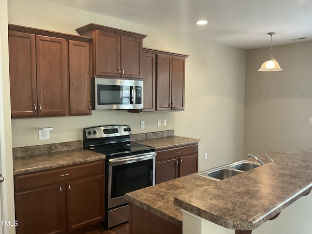 kitchen featuring dark countertops, visible vents, appliances with stainless steel finishes, and a sink