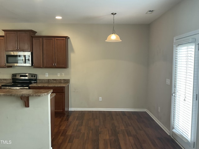 kitchen featuring recessed lighting, stainless steel appliances, baseboards, dark wood-style flooring, and hanging light fixtures