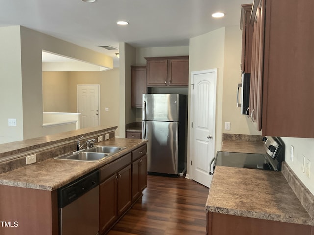 kitchen with dark wood-type flooring, recessed lighting, appliances with stainless steel finishes, and a sink