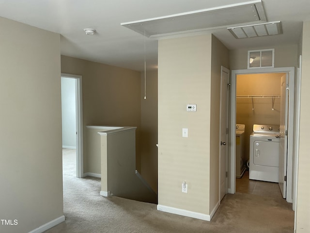 corridor featuring visible vents, attic access, carpet floors, an upstairs landing, and independent washer and dryer