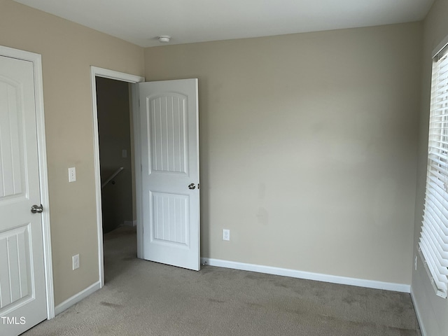 unfurnished bedroom featuring carpet and baseboards