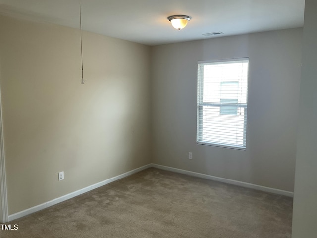 unfurnished room with visible vents, baseboards, and carpet