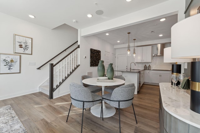 dining space featuring recessed lighting, stairs, baseboards, and wood finished floors