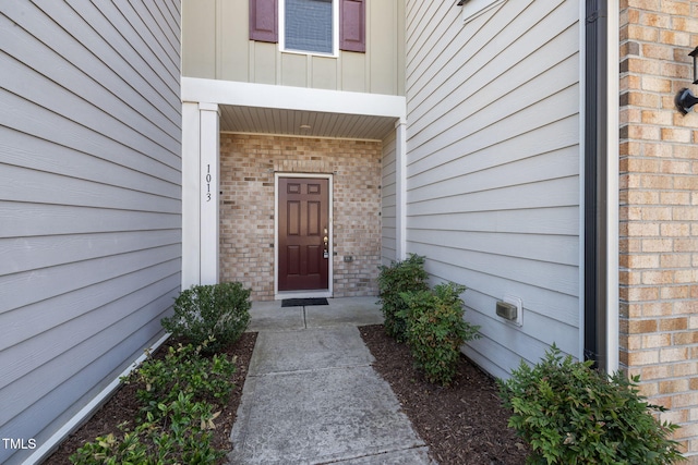 entrance to property featuring brick siding and board and batten siding