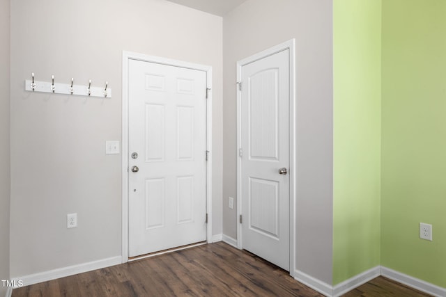 foyer featuring baseboards and dark wood-style flooring