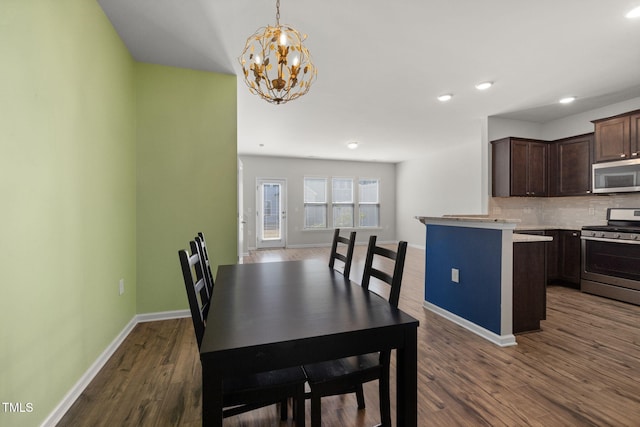 dining area featuring recessed lighting, dark wood-style floors, baseboards, and a chandelier