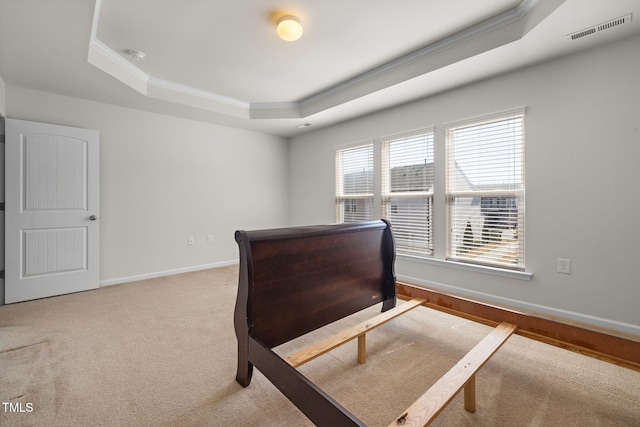 bedroom with visible vents, baseboards, carpet, a tray ceiling, and ornamental molding