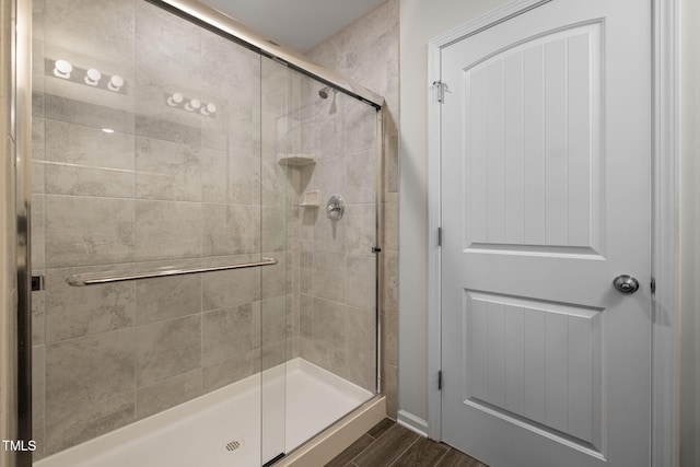 bathroom with a stall shower and wood finished floors