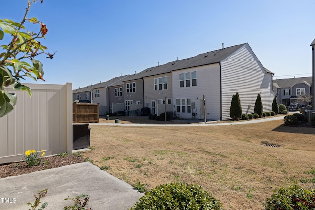 rear view of house featuring a yard, a residential view, and a patio