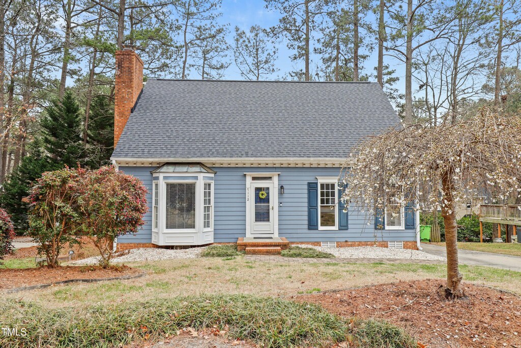 7112 Benhart Dr, Raleigh, NC 27613 - cape cod home with a chimney, a front lawn, and roof with shingles