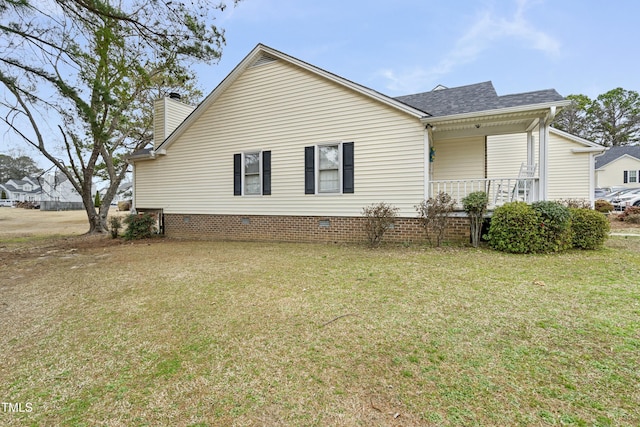 view of side of home featuring a shingled roof, a porch, a lawn, and a chimney