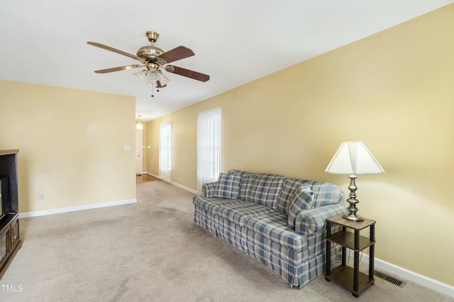 carpeted living room featuring visible vents, baseboards, and ceiling fan