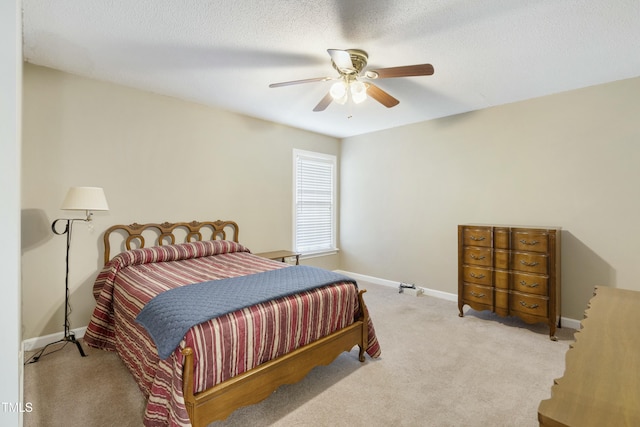 bedroom featuring carpet flooring, a textured ceiling, a ceiling fan, and baseboards