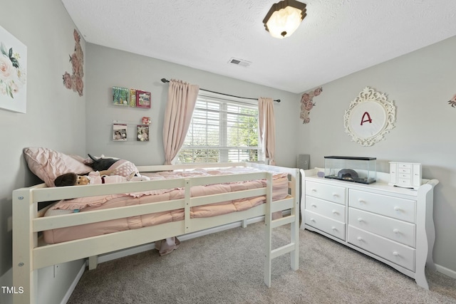 bedroom featuring visible vents, a textured ceiling, and carpet flooring