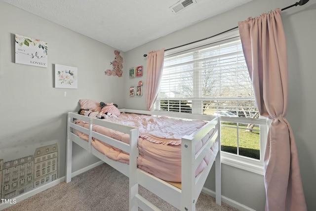 bedroom with carpet flooring, baseboards, visible vents, and a textured ceiling