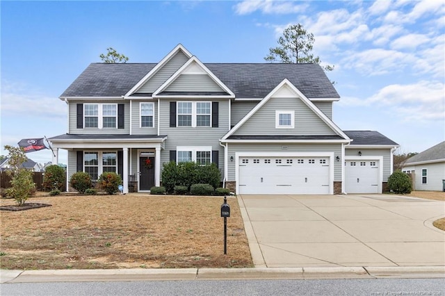 view of front of home featuring covered porch, driveway, an attached garage, and a front lawn