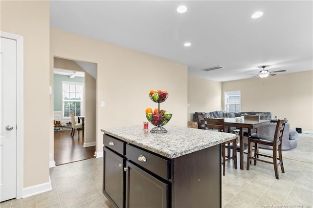 kitchen with visible vents, open floor plan, a center island, recessed lighting, and ceiling fan