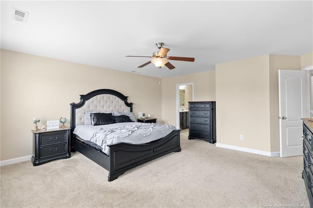 bedroom featuring visible vents, ensuite bathroom, a ceiling fan, baseboards, and light colored carpet