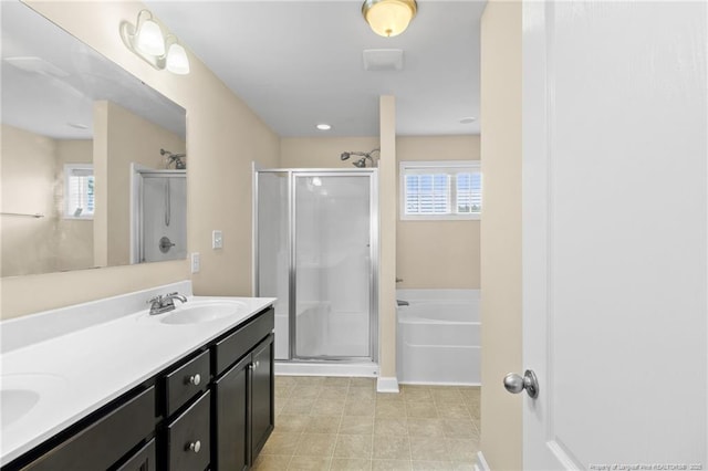 bathroom featuring double vanity, a shower stall, a bath, and a sink