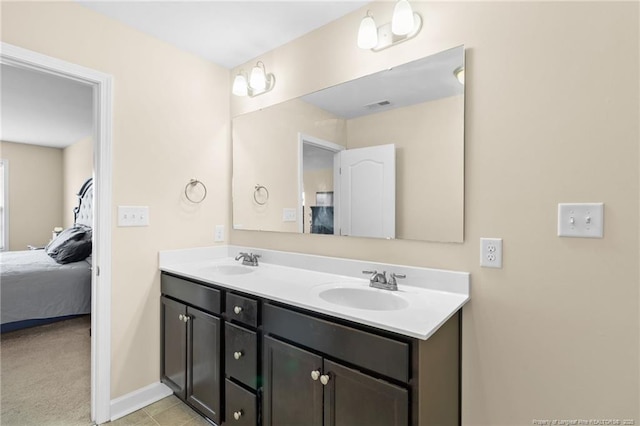 ensuite bathroom with double vanity, visible vents, ensuite bathroom, and a sink