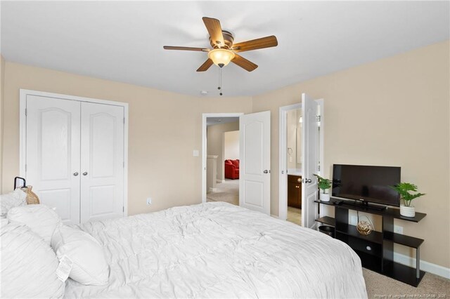 bedroom with a closet, ceiling fan, light carpet, and baseboards