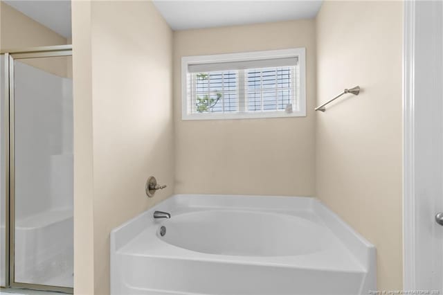 bathroom featuring a shower stall and a garden tub