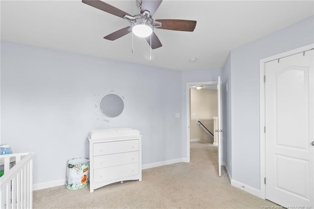 carpeted bedroom with a ceiling fan and baseboards