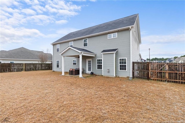 rear view of property featuring a fenced backyard