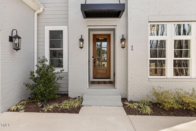 doorway to property featuring brick siding