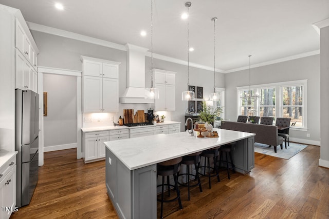 kitchen featuring crown molding, custom range hood, an island with sink, and dark wood-style flooring