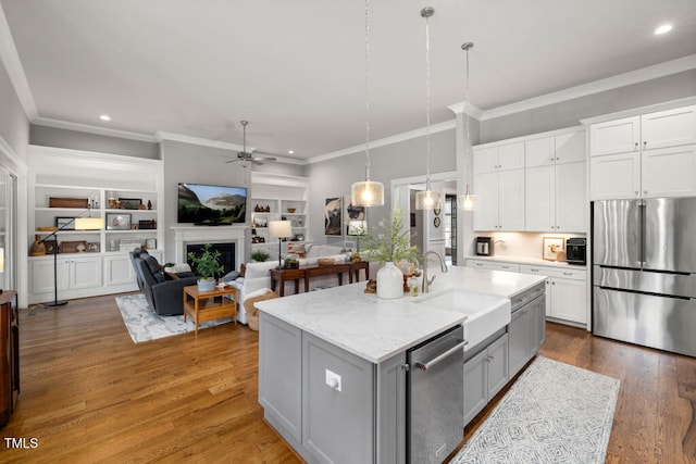 kitchen featuring a ceiling fan, gray cabinets, ornamental molding, a sink, and appliances with stainless steel finishes