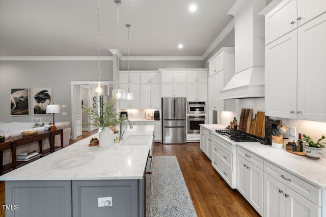 kitchen featuring ornamental molding, a sink, tasteful backsplash, stainless steel appliances, and wall chimney exhaust hood