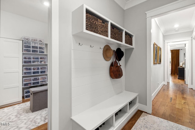 mudroom featuring ornamental molding, baseboards, and wood finished floors