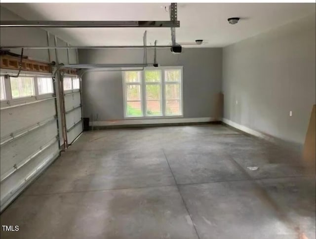 garage with baseboards and a garage door opener