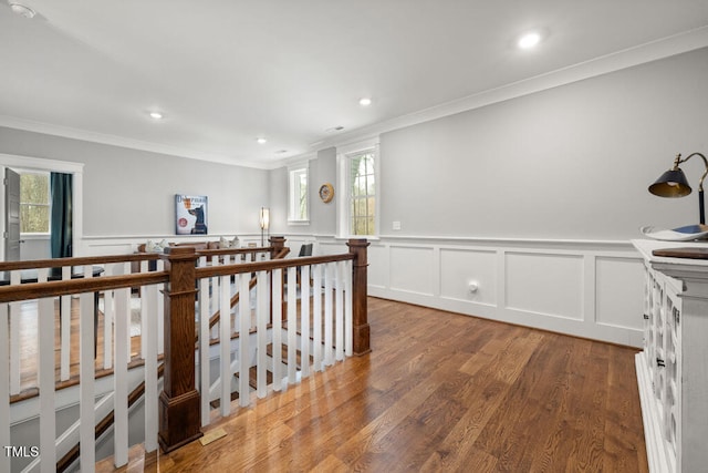 hallway featuring an upstairs landing, recessed lighting, crown molding, and wood finished floors