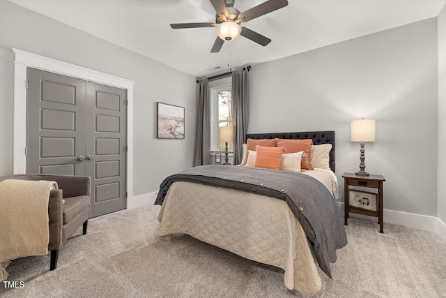 bedroom featuring light colored carpet, baseboards, and ceiling fan