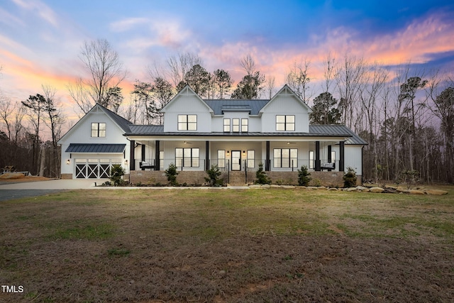 modern farmhouse style home featuring a garage, a porch, metal roof, and a standing seam roof