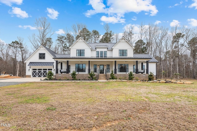 modern inspired farmhouse with metal roof, a porch, driveway, and a standing seam roof