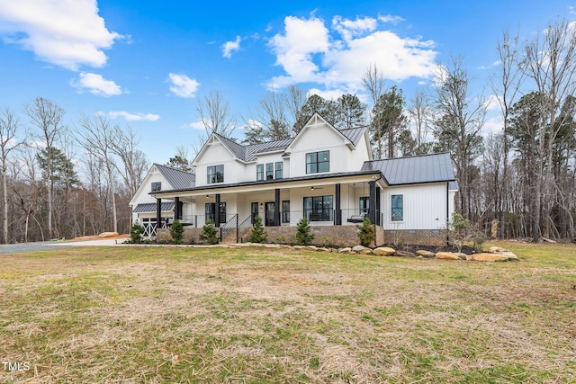 modern farmhouse style home with metal roof, a porch, a front lawn, and a standing seam roof