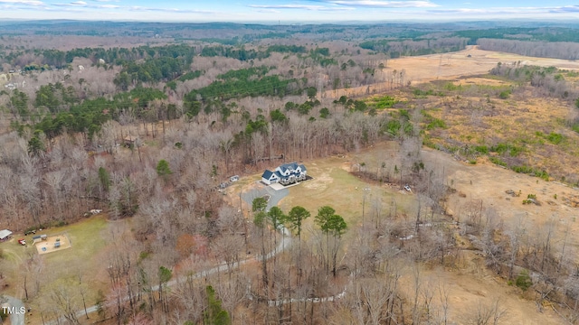 drone / aerial view featuring a wooded view