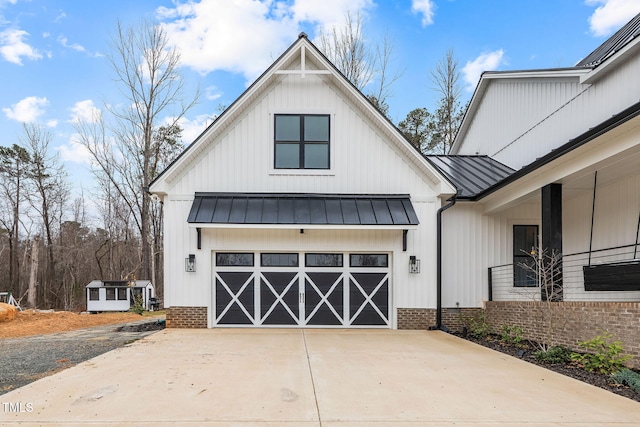 view of front of property featuring metal roof, board and batten siding, driveway, and a standing seam roof