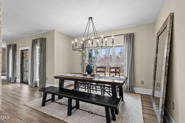 dining room featuring baseboards, a notable chandelier, and wood finished floors